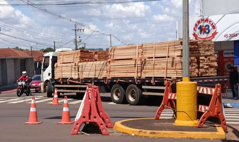 Caminhão carregado com madeira fica preso em estrutura de contenção e bloqueia trânsito no Centro de Toledo