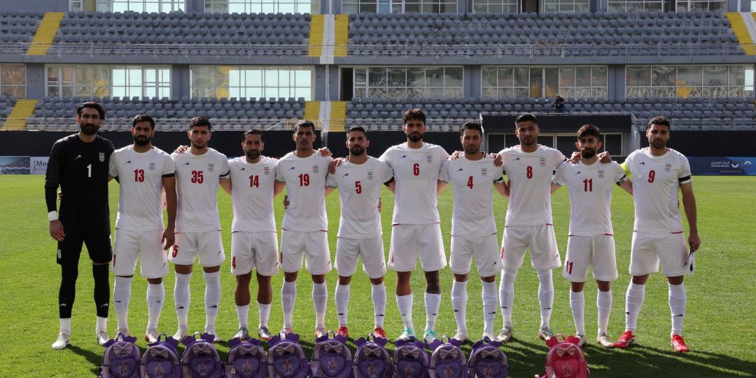 Jogadores iranianos seguram mochilas em protesto por meninas mortas