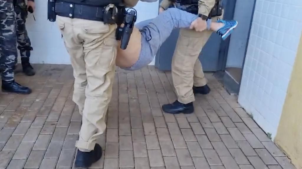 Caindo de bêbado, motorista é carregado por policiais na delegacia de Cascavel